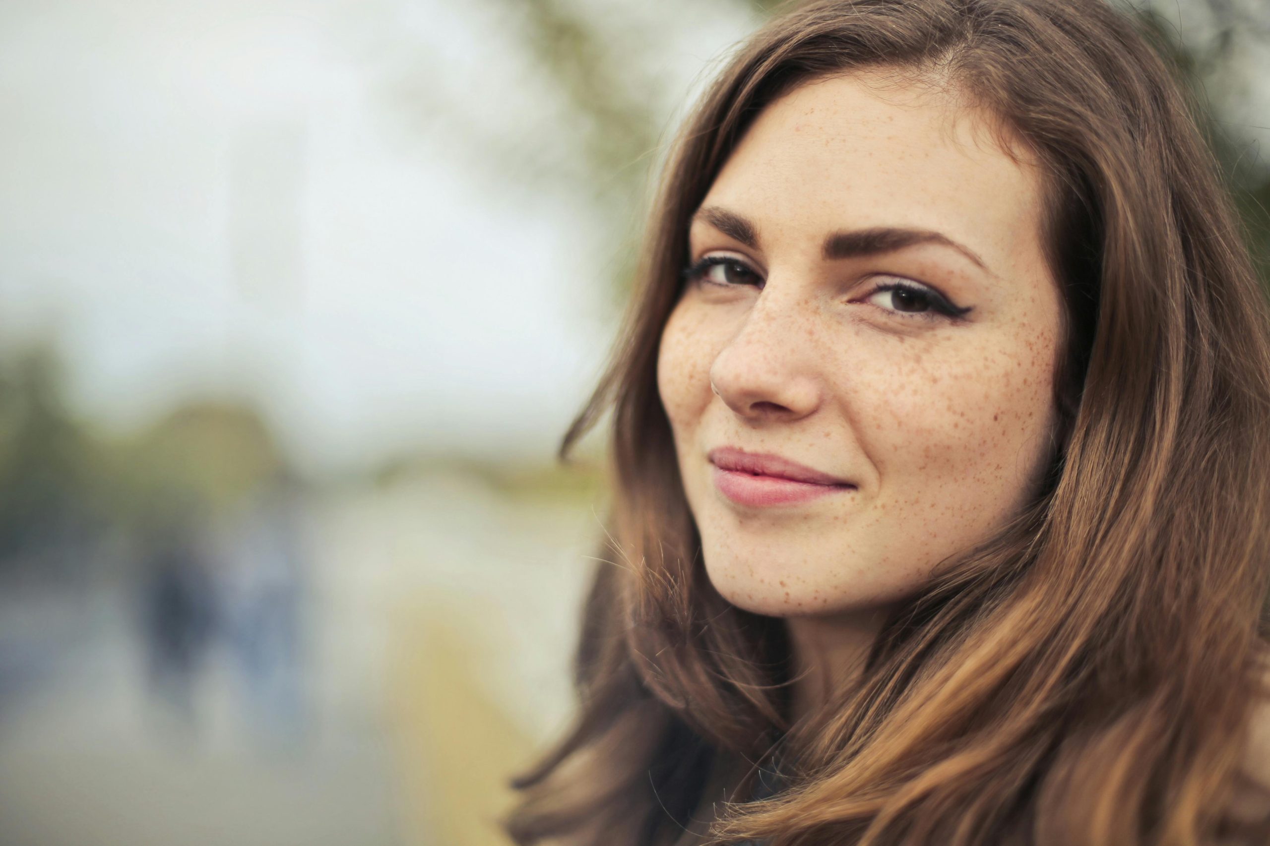 Close-up portrait of a smiling young woman outdoors in Budapest.